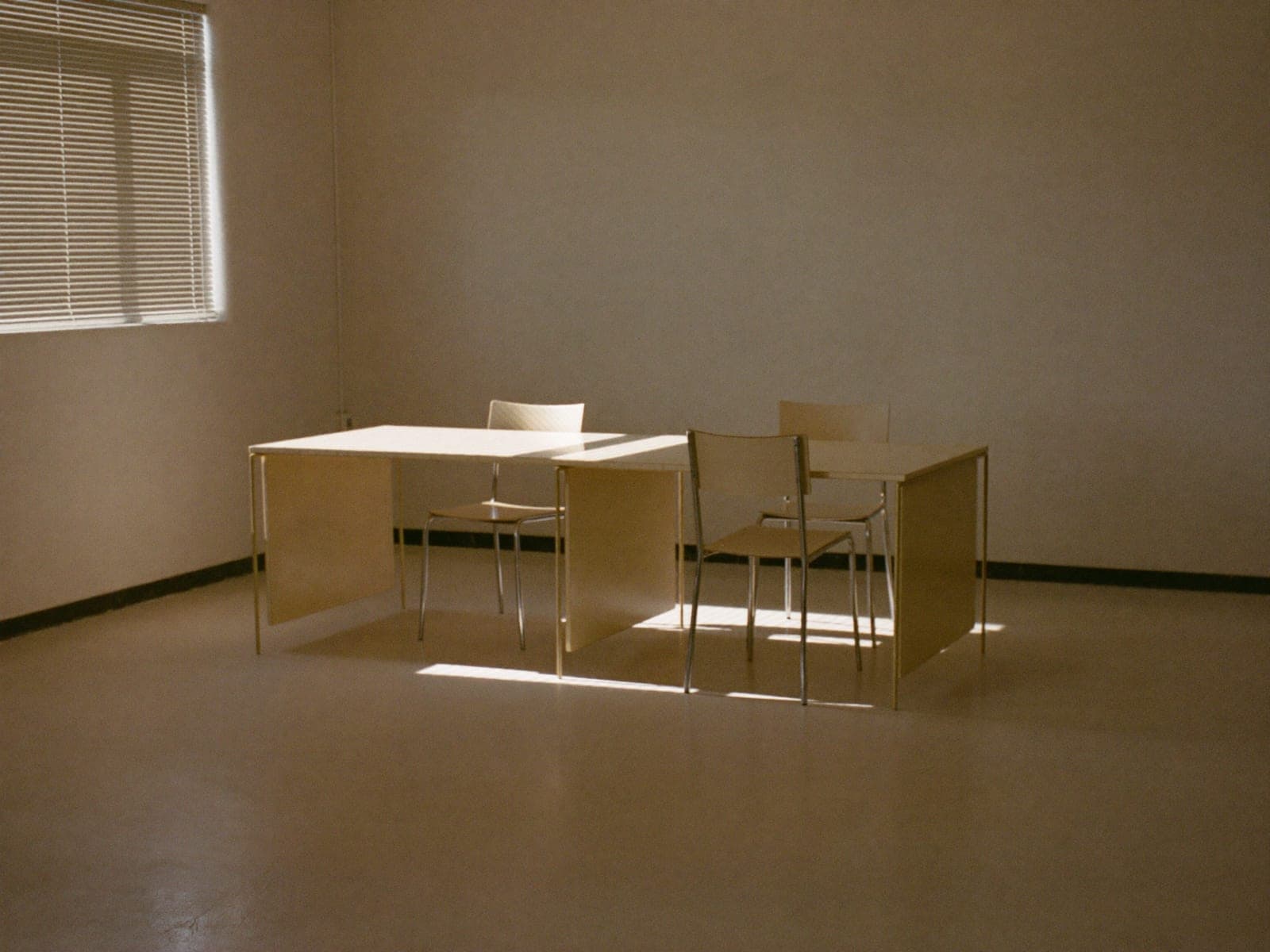An empty office at dawn, desks clear and floors freshly cleaned.